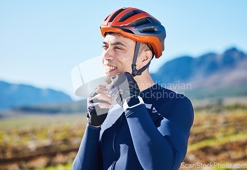 Image of Mountain, helmet and face of man cycling for fitness, training or competition or sports adventure with blue sky. Gear, athlete and safety in outdoor cycle, bike ride or exercise in nature or park