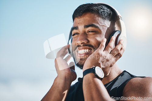 Image of Thinking, beach and a man with music for fitness, running motivation and ideas in nature. Smile, wellness and an athlete listening or streaming a podcast while training or exercise vision at the sea