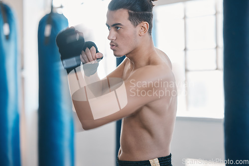 Image of Sports, boxing and man punch for mma fight in gym for training, workout and martial arts exercise. Fitness, body builder and serious male athlete ready for boxer competition, practice and performance