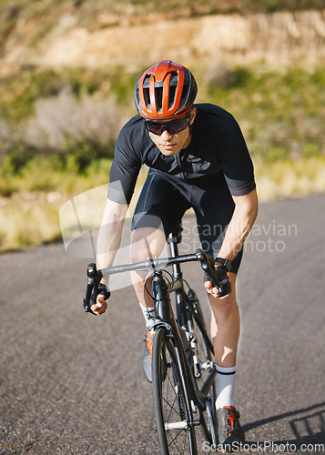 Image of Exercise, bike and cycling with a sports man on a road through the mountain for cardio or endurance. Fitness, workout or training with a male cyclist riding his bicycle on an asphalt street in nature