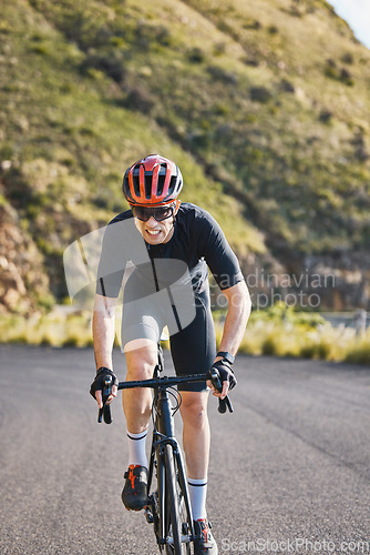 Image of Fitness, bike and cycling with a sports man on a road through the mountain for cardio or endurance. Exercise, workout or training with a male cyclist riding his bicycle on an asphalt street in nature