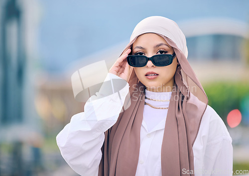 Image of Portrait, fashion or sunglasses with a muslim woman in saudi arabia wearing a cap and scarf for contemporary style. Islam, faith and hijab with a trendy young arab person posing outside in shades