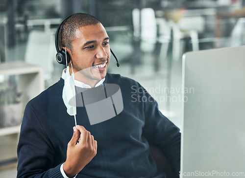 Image of Customer service, man call center agent with face mask and headset with computer at his modern office workplace. Online communication or networking, crm or telemarketing and male person for support