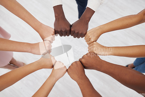 Image of Hands, collaboration and overhead with a business team standing in a circle for unity or solidarity at work. Teamwork, fist bump and support with a diverse group of colleagues in a huddle from above