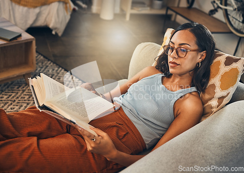 Image of Woman relax on sofa, reading book at house and break on the weekend with literature, fantasy story and peace. Female person with hobby, leisure and chill at home, read for knowledge and information