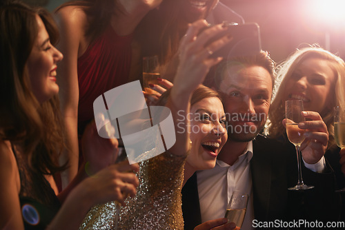 Image of Selfie, party and new year with friends in a nightclub posing for photograph of celebration together. Champagne, toast and nightlife with a group of people taking a picture in a club while dancing