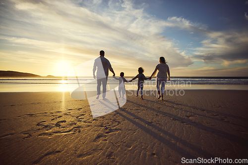 Image of Sunrise, beach and back of family holding hands and walking on holiday, summer vacation and weekend. Nature, travel and mother, father and children by ocean for bonding, adventure and quality time