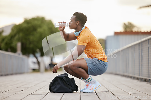 Image of Drink, fitness and black man with water bottle in exercise, training or outdoor cardio workout. Athlete, drinking and healthy hydration or person relax after running in summer sport practice