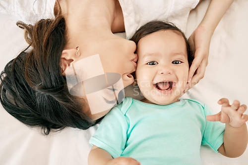 Image of Top view, bed and mother kiss baby for bonding, quality time or loving support together at home. Newborn face, portrait or above of mom and happy infant for care, relationship or affection in bedroom