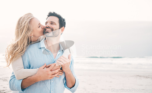 Image of Beach, love and couple hug and kiss on holiday, vacation and romantic weekend for anniversary. Mockup space, marriage and mature man embrace woman for bonding, quality time and happiness by ocean