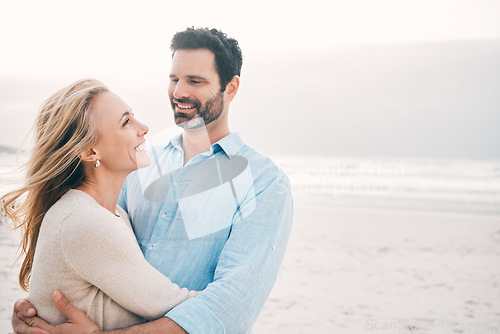 Image of Beach, hug and couple with smile in nature on holiday, vacation and romantic weekend for anniversary. Love, marriage and happy mature man hugging woman for bonding, quality time and relax by ocean