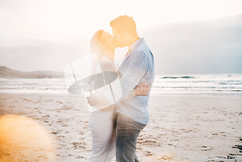 Image of Beach, lens flare and couple kiss for love on holiday, vacation and romantic weekend for anniversary. Travel, marriage and mature man kissing woman for bonding, quality time and happiness by ocean