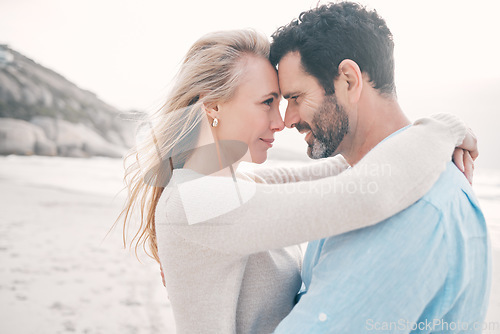 Image of Beach, love and couple touching head on holiday, vacation and romantic weekend for anniversary. Intimacy, marriage and happy mature man hugging woman for bonding, quality time and happiness by ocean