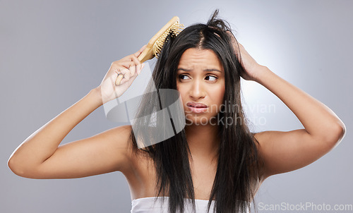 Image of Hair, damage and woman with brush in studio with worry for knots, haircare crisis and weak texture. Beauty, hairdresser and face of female person with frizz, tangle and dry problem on gray background