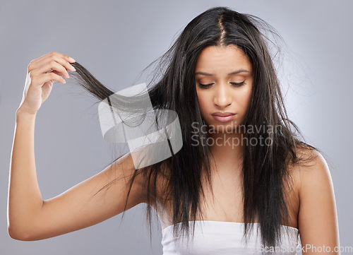 Image of Hair care, damage and face of woman in studio with worry for split end, haircare crisis and weak strand. Beauty, hairdresser and upset female person with frizz, dry or loss problem on gray background