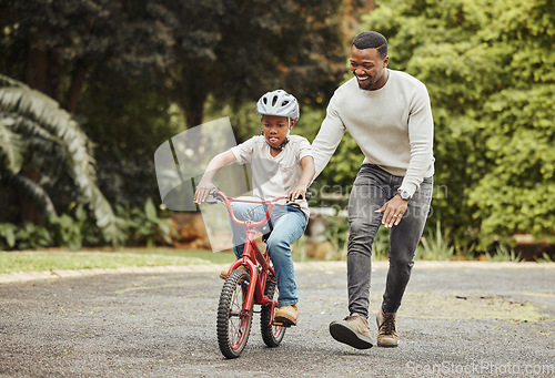 Image of Black family, father teaching child cycling in park with bicycle and helmet for safety, learning and help. Support, motivation and trust, man with boy outdoor and learn bike riding with mockup space