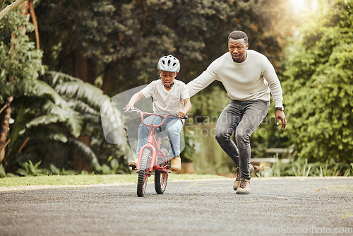Image of Family, father teaching child cycling in park with bicycle and helmet for safety, learning and help. Support, motivation and trust, black man with boy outdoor and learn bike riding with mockup space