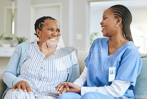 Image of Senior woman, nurse and laughing together for support, healthcare and happiness at retirement home. Black person or patient and caregiver holding hands for trust, elderly care and help for wellness