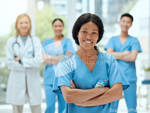 Image of Portrait, medicine and a black woman nurse arms crossed, standing with her team in a hospital for healthcare. Leadership, teamwork and a female health professional in a medical clinic for treatment