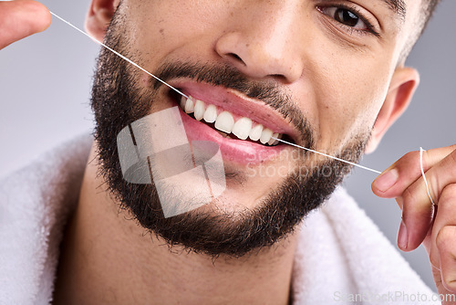 Image of Face, man and flossing teeth for dental health in studio isolated on a white background. Portrait, floss and male model cleaning tooth for oral wellness, hygiene and healthy gums for fresh breath.