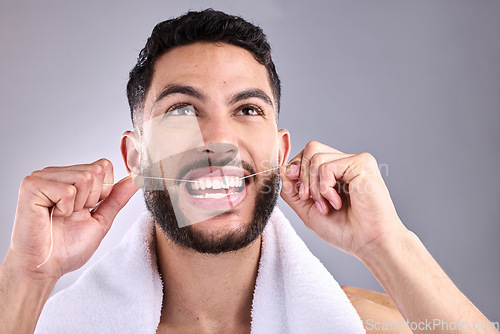 Image of Face, man and floss teeth for dental health in studio isolated on a white background. Tooth, flossing and male model cleaning for oral wellness, fresh breath and healthy hygiene to stop gingivitis.