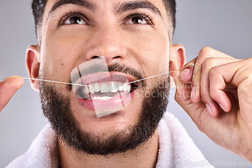 Image of Face, dental and man floss teeth in studio isolated on a white background. Tooth, flossing product and male model cleaning for oral wellness, fresh breath and healthy hygiene to stop gingivitis.