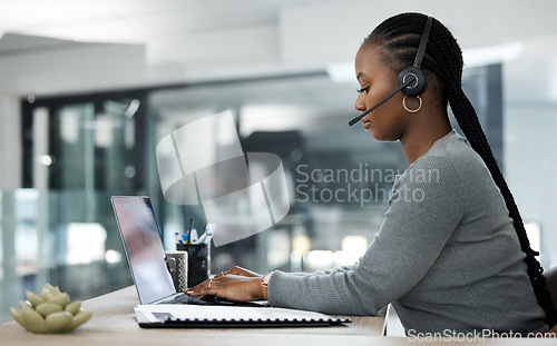 Image of Black woman, laptop and call center in customer service, telemarketing or support at the office desk. African female person, consultant or agent typing on computer with headphones for online advice