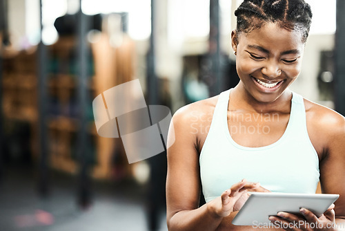 Image of Happy, black woman with a tablet and in a gym with a smile for inventory. Fitness or workout, training or exercise for motivation and African female athlete smiling for health wellness in sportswear