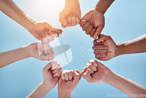 Image of Team building, fist bump and hands in a circle together for unity, collaboration and connection. Solidarity, diversity and closeup of a group of multiracial people in a round shape by sky background.