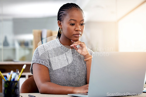 Image of Laptop, research and a business black woman thinking while working at her desk in her office with flare. Computer, planning and idea with a serious young female employee reading an email at work