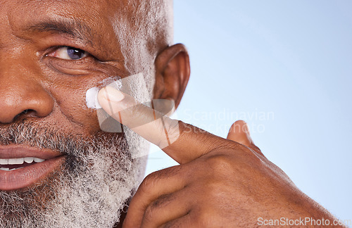 Image of Skincare, cream and closeup of black man in studio for sunscreen anti aging or beauty. Cosmetics, mockup or self care with lotion on face of senior model on blue background for facial and spa product