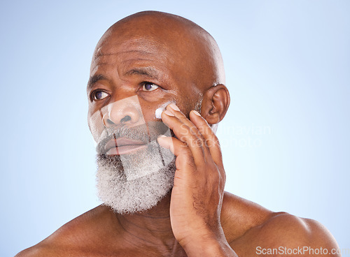 Image of Skincare, cream and face of black man in studio for sunscreen anti aging or beauty. Cosmetics, mockup or self care with lotion with senior model on blue background for facial, glow and spa product
