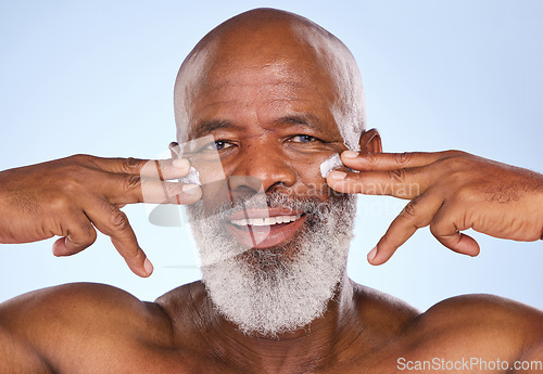 Image of Skincare, cream and happy with portrait of black man in studio for sunscreen, anti aging or beauty. Cosmetics, mockup or self care with face lotion on model on blue background for facial and product