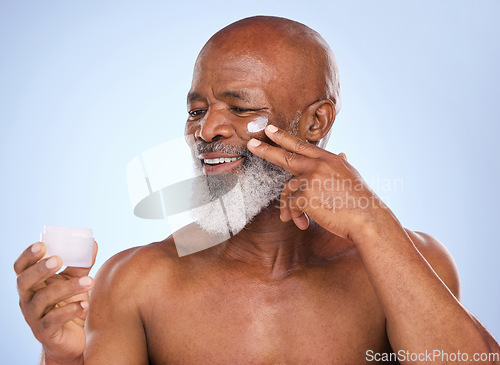 Image of Skincare, cream and product with black man in studio for sunscreen, anti aging or beauty. Cosmetics, mockup or self care with lotion on face of model on blue background for facial and spa treatment