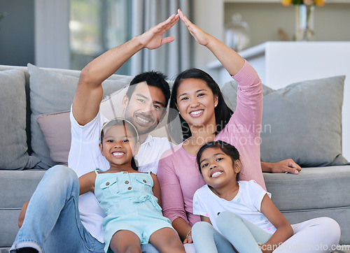 Image of Hand roof, portrait and family in a house for safety, security and investment. Happy, love and parents and children with hands to cover for family insurance, mortgage or property on the lounge floor