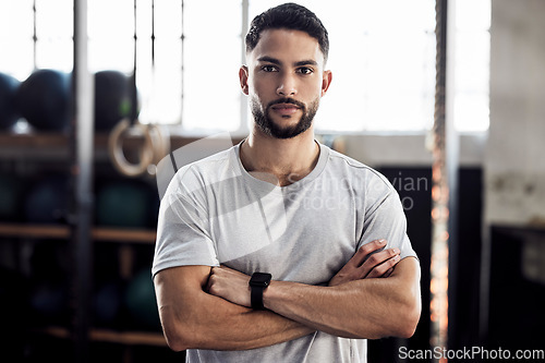 Image of Fitness, exercise and portrait of a serious man at gym for a training workout with focus. Face of male athlete or personal trainer with strong muscle, power and motivation with arms crossed at club