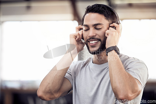 Image of Headphones, listening to music and a man at gym for exercise, fitness or training workout. Face of happy male athlete listen to audio, sound or radio with tech for motivation, mindset and to relax