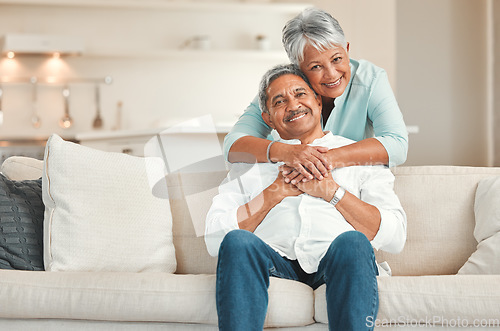 Image of Senior couple, couch and portrait with hug, smile and love in home living room with care, romance or happiness. Elderly man, old woman and embrace by lounge sofa in relax retirement together in house