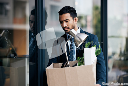 Image of Depression, economy and a business man with a box walking outdoor in the city after being fired. Financial crisis, unemployment and dismissal with a young male employee looking sad in an urban town