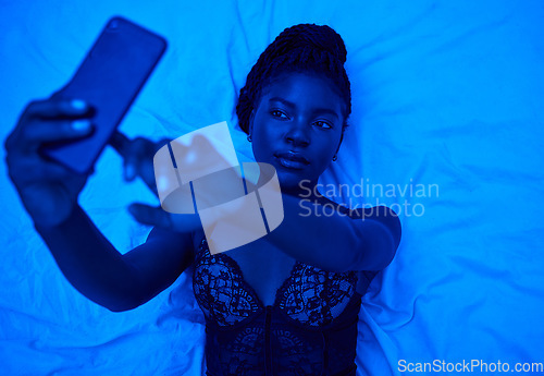 Image of Sexy selfie, bed and black woman with lighting for a photo for social media or online chat. Above, blue room and an African person taking pictures on a mobile in lingerie for web, an app or sexting