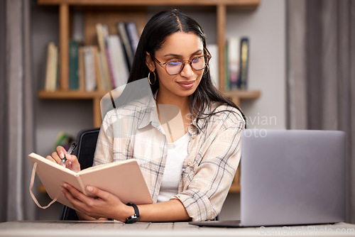 Image of Laptop, notebook and learning with a student woman in a university library to study for a final exam. Technology, education and diary with a young female college pupil reading research material