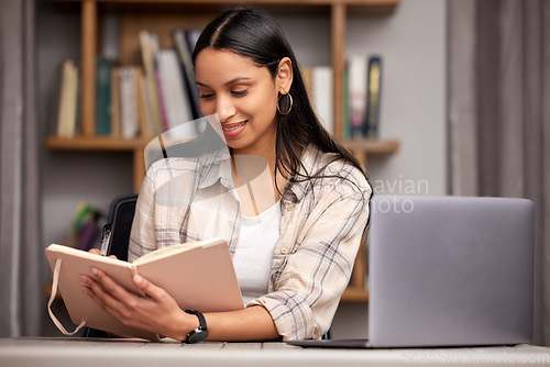 Image of Laptop, book and education with a student woman in a university library to study for a final exam or test. Technology, learning and journal with a young female college pupil reading research material