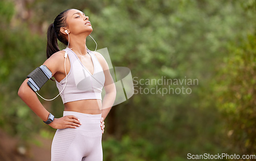 Image of Running break, tired and woman with music in nature for fitness, exercise and a workout. Sports, rest and young athlete with audio or a playlist while training with cardio in a park with mockup space