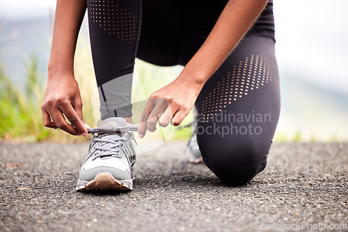 Image of Sport, feet of woman tying sneakers and runner on road for safety during outdoor marathon training. Running, cardio health and wellness, female athlete fixing laces on footwear and closeup of asphalt