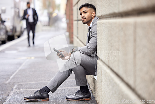 Image of Thinking, phone and a businessman sitting in the city for social media, communication or email. Contact, ideas and a corporate person in a suit with a mobile for a chat, internet or notification