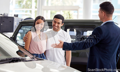 Image of Couple at car dealership, choice and transportation with salesman, customer buying new transport with luxury. Sales, agreement and show cars with people at automobile showroom with purchase decision