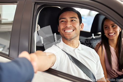 Image of Car dealership, man and handshake from purchase and loan deal at motor showroom with salesman. Couple, happy and smile with shaking hands from agreement, payment and contract with a transport sale