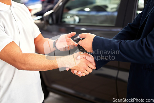 Image of Car dealership, man hands and handshake from purchase and loan deal at motor showroom with salesman. Male person with shaking hands from agreement, payment success and contract with a transport sale