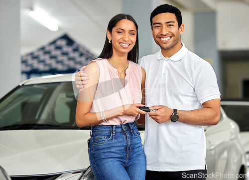 Image of Couple at car dealership, choice and transport with key, people buy new vehicle with luxury and smile in portrait. Happy with decision, man and woman at automobile showroom with purchase and cars