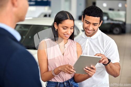 Image of Tablet, car and showroom with couple and salesman for vehicle shopping, test drive and consulting. Auto, transportation and purchase with man and woman in dealership for insurance, sale and motor